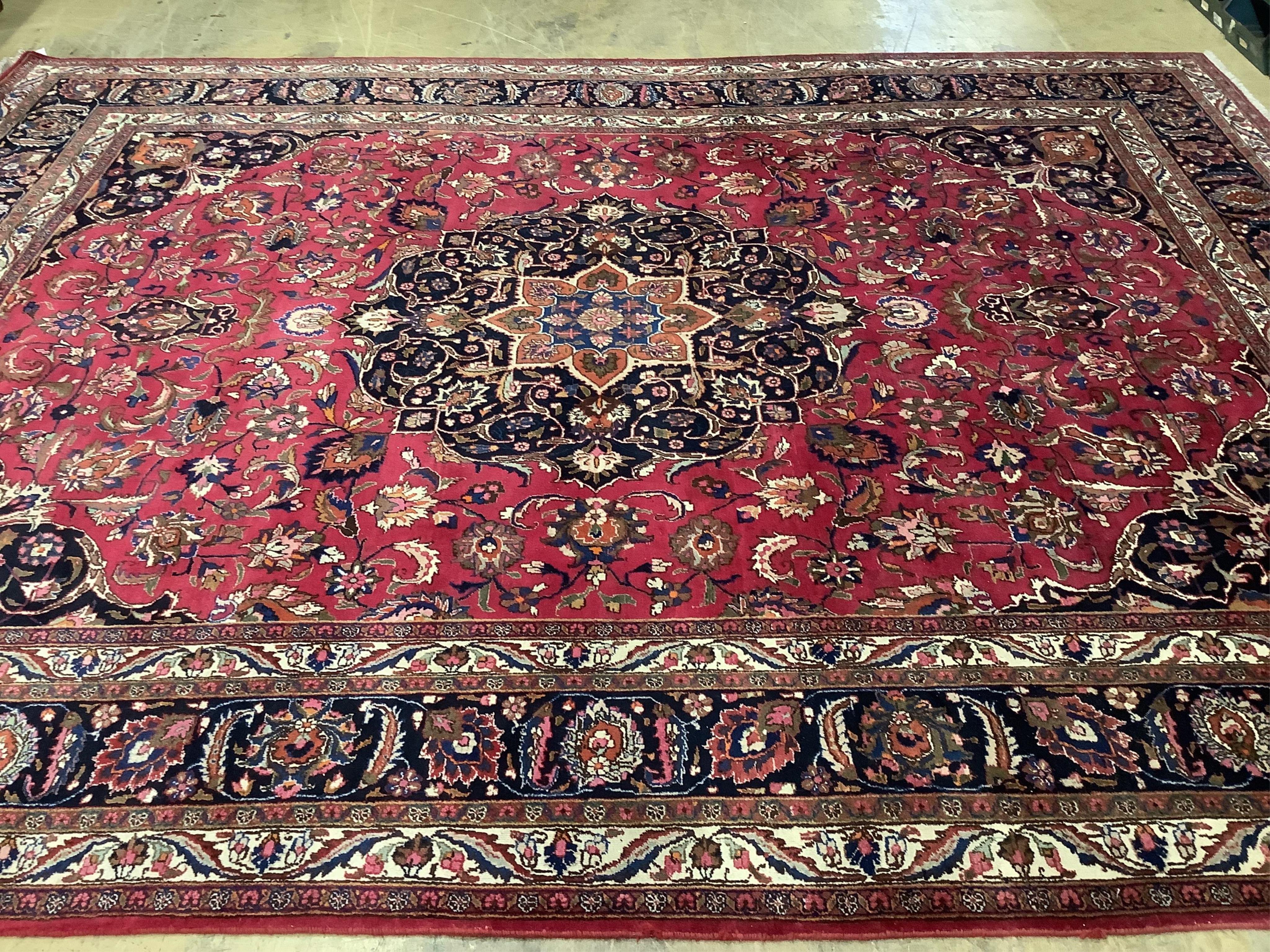 A Heriz burgundy ground floral carpet, 392cm x 299cm. Condition - good